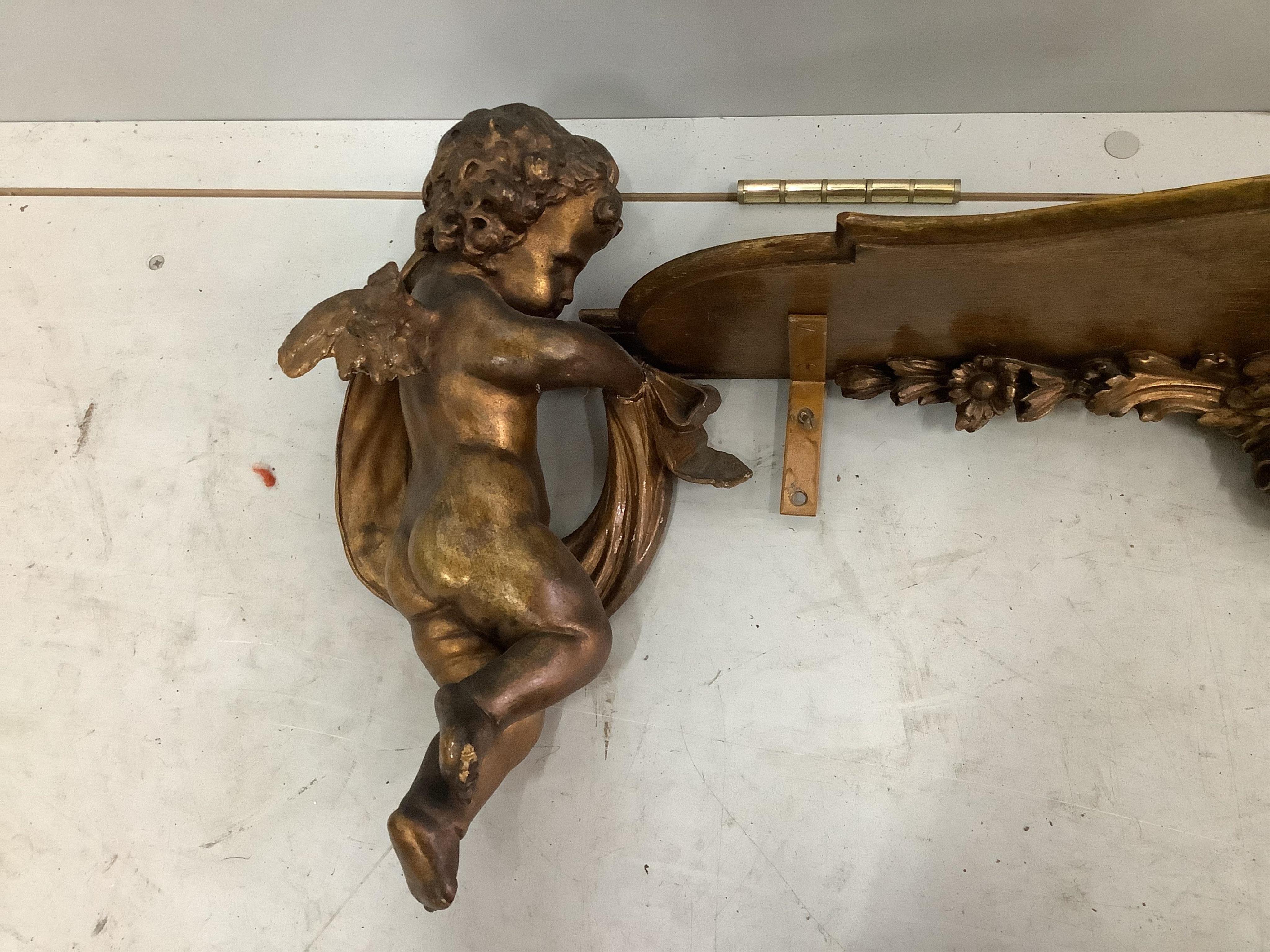 An 18th century style gilt composition cherub wall bracket, width 95cm. Condition - poor to fair